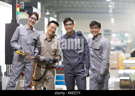 Confident Chinese engineering team in the factory Stock Photo