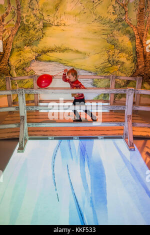 London, UK. 4th Dec, 2017. Playing on the poohsticks bridge - Winnie-the-Pooh: Exploring a Classic exhibition: Winnie-the-Pooh’s Poohsticks Bridge and Hundred Acre Wood brought to life at the Victoria & Albert Museum. The exhibition opens to the public on 9 December 2017 and runs until 8 April 2018. London 04 Dec 2017. Stock Photo