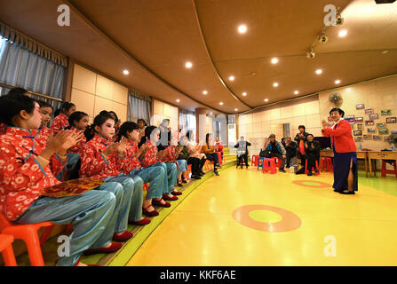 (171205) -- LIUZHOU, Dec. 5, 2017 (Xinhua) -- Li Fusong (1st R), 79, a retired teacher, directs children to perform the Peking Opera at the children's center in Liuzhou City, south China's Guangxi Zhuang Autonomous Region, Dec. 3, 2017. Li has been fond of the Peking Opera since childhood, but she didn't get the chance to learn the opera until her retirement in 1994. During her self-study in the following ten years, she found that most of the opera fans were just middle-aged and old people. She then made a resolution to pass on the traditional art to young people with her own efforts. Li opene Stock Photo