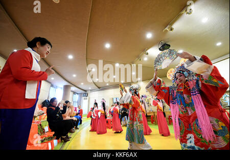 (171205) -- LIUZHOU, Dec. 5, 2017 (Xinhua) -- Li Fusong (1st L), 79, a retired teacher, directs children to perform the Peking Opera at the children's center in Liuzhou City, south China's Guangxi Zhuang Autonomous Region, Dec. 3, 2017. Li has been fond of the Peking Opera since childhood, but she didn't get the chance to learn the opera until her retirement in 1994. During her self-study in the following ten years, she found that most of the opera fans were just middle-aged and old people. She then made a resolution to pass on the traditional art to young people with her own efforts. Li opene Stock Photo