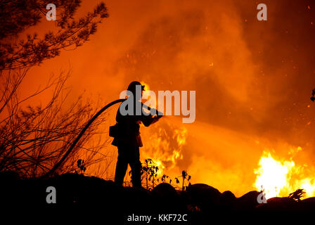 Santa Paula, USA. 5th Dec, 2017. A firefighter battles a wildfire in Santa Paula, Ventura, the United States, on Dec. 5, 2017. Fast moving brush fire exploded to more than 10,000 acres (40 square km) Monday night in Ventura County in the western U.S. state of California, threatening homes in nearby cities and leading to the death of one person. Credit: Xinhua/Alamy Live News Stock Photo