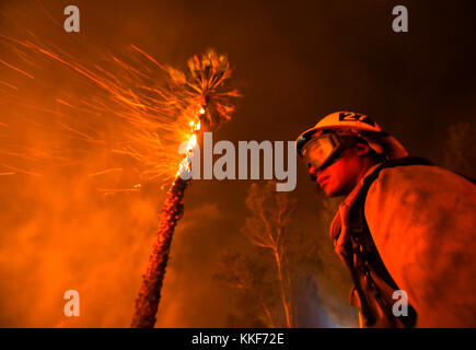 Santa Paula, USA. 5th Dec, 2017. A firefighter battles a wildfire in Santa Paula, Ventura, the United States, on Dec. 5, 2017. Fast moving brush fire exploded to more than 10,000 acres (40 square km) Monday night in Ventura County in the western U.S. state of California, threatening homes in nearby cities and leading to the death of one person. Credit: Xinhua/Alamy Live News Stock Photo