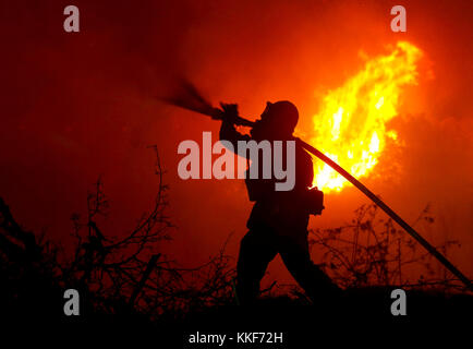 Santa Paula, USA. 5th Dec, 2017. A firefighter battles a wildfire in Santa Paula, Ventura, the United States, on Dec. 5, 2017. Fast moving brush fire exploded to more than 10,000 acres (40 square km) Monday night in Ventura County in the western U.S. state of California, threatening homes in nearby cities and leading to the death of one person. Credit: Xinhua/Alamy Live News Stock Photo