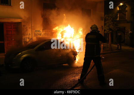 Athens, Greece. 6th Dec, 2017. A firefighter extinguishes the fire on a car during a rally commemorating the death of a teenage student in Athens, Greece, on Dec. 6, 2017. Clashes with anti-riot forces ended a series of rallies organized by student unions, left-wing parties and anti-establishment groups in the center of Athens on Wednesday to mark the ninth anniversary of the fatal police shooting of the 15-year-old high school student Alexandros Grigoropoulos in 2008. Credit: Marios Lolos/Xinhua/Alamy Live News Stock Photo