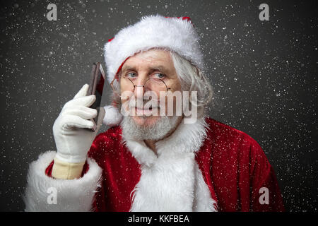 Santa Claus using smartphone - calling phone or texting a message Closeup Portrait Stock Photo