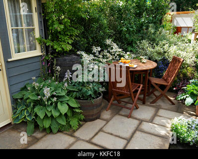 Seating in a small urban patio garden with outdoor eating Stock Photo