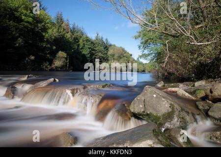 A long exposure photograph of the river Wear in full flow as it passes down by Witton le Wear in County Durham, North East England. Stock Photo