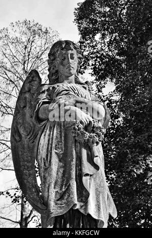 A pensive angel blows her head in sorrow over a grave in historic Hollywood Cemetery in Richmond, Virginia. Stock Photo