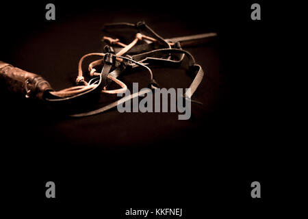 Cat-o-nine-tails Whip from the Easter Passion Story, as used to Torture Jesus Christ before his Crucifixion, on a dark background Stock Photo