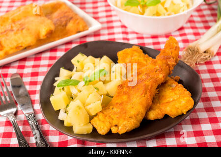 Fried catfish and potato salad in the plate.Selective focus on the fried fish Stock Photo