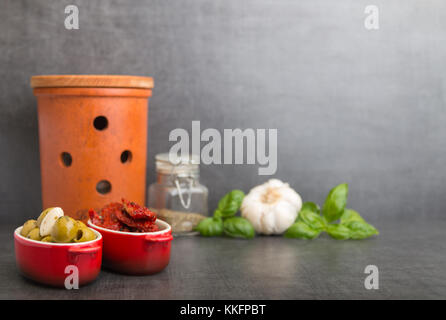 olives and dried tomatoes and spices on a stone background Stock Photo
