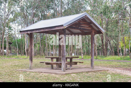 A simple picnic shed with a table and benches in a reservation. Stock Photo