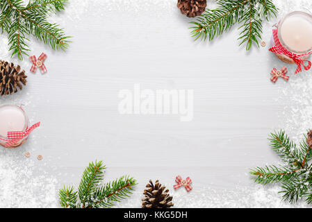 Flat Christmas background scene with fir branches, bows, candles, pinecones and snowflakes Free space for copy text on white board. Top view. Stock Photo