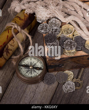 Old brass compass with gold and silver coins and treasure map Stock ...