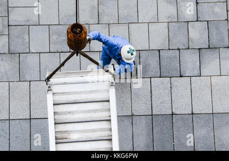 Dock worker positions lowering of ramp from crane for cruise ship. Looking down on worker position equipment using crane. Teamwork concept. Stock Photo