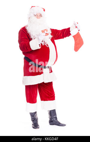 Santa hiding gift into stocking Stock Photo