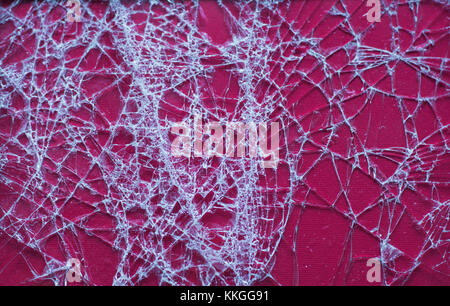 Cracked glass on a red background, background, texture. Broken glass. Stock Photo