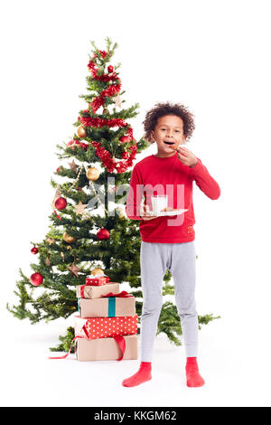 Mixed race boy near Christmas tree Stock Photo