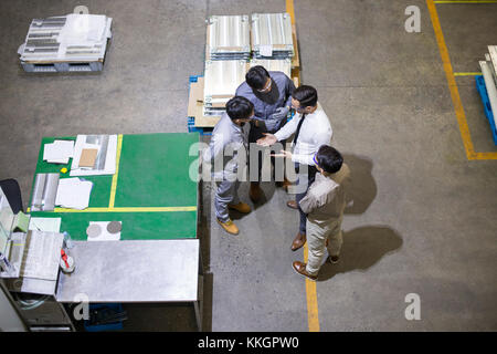 Businessman and engineers talking in the factory Stock Photo