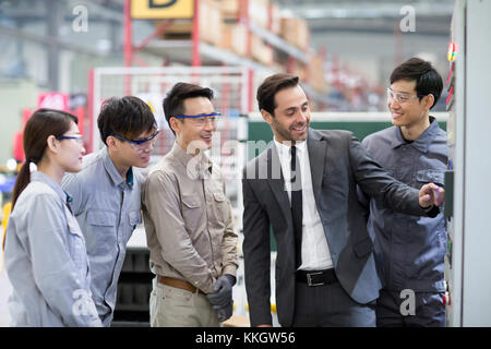 Businessman and engineers talking in the factory Stock Photo