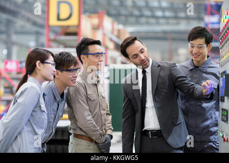 Businessman and engineers talking in the factory Stock Photo