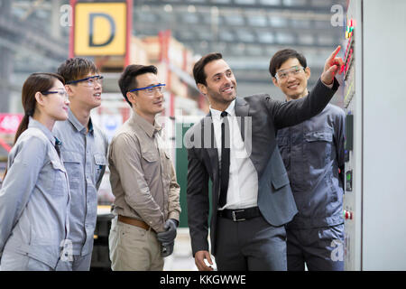 Businessman and engineers talking in the factory Stock Photo