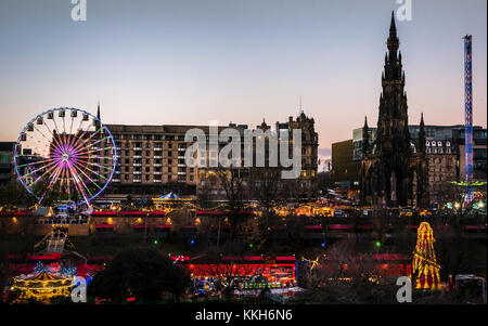 Edinburgh, Scotland, United Kingdom, 30th November 2017.  Edinburgh Christmas celebrations Christmas Market and fairground rides, with the Forth 1 big wheel dominating the view across Princes Street Gardens, and a helter skelter.  The city centre is lit up with wonderful colourful lights at sunset on a Winter evening Stock Photo