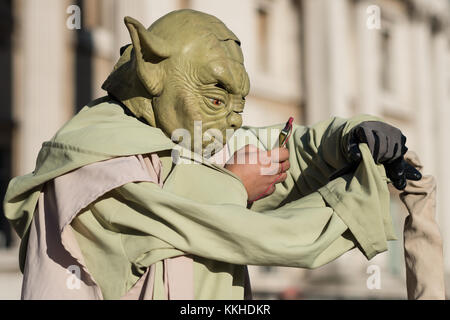 London, UK. 1st Dec, 2017. A floating Yoda street performer checks his phone during a break in Trafalgar Square. Credit: Guy Corbishley/Alamy Live News Stock Photo
