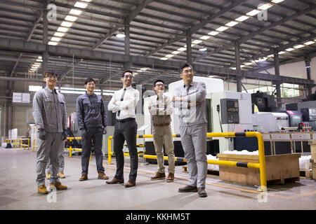 Confident businessman and engineering team in the factory Stock Photo