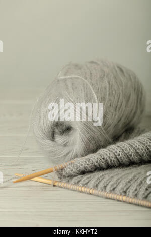Knitting from woolen threads of gray color. Selective focus. Stock Photo