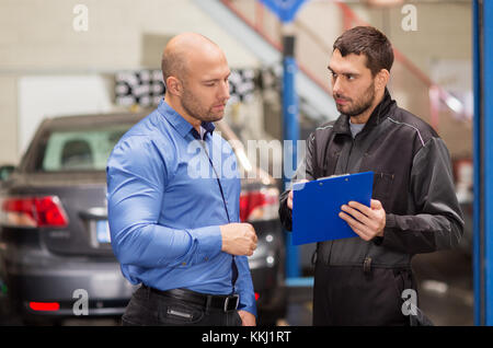 auto mechanic and customer at car shop Stock Photo