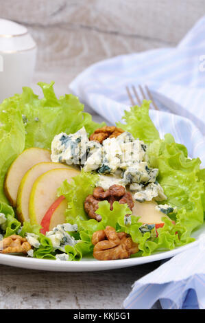 A light lettuce salad with pear slices, gorgonzola pieces and walnut seasoned with olive oil Stock Photo