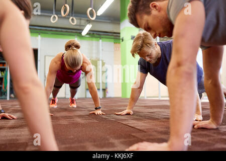 group of people doing straight arm plank in gym Stock Photo