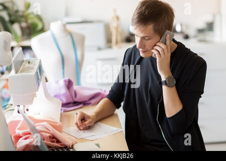 fashion designer calling on smartphone at studio Stock Photo