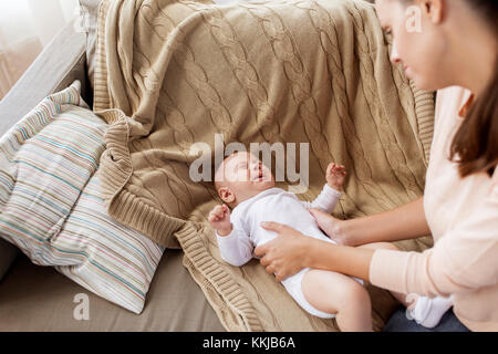 mother soothing crying little baby boy at home Stock Photo