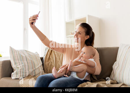 happy mother with baby boy taking selfie at home Stock Photo
