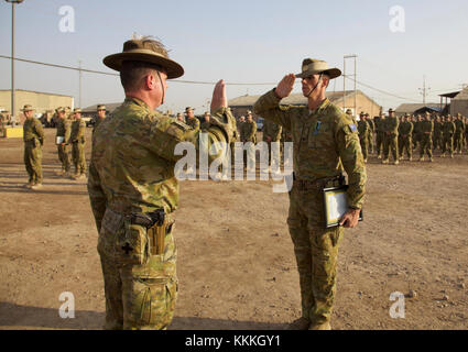 An Australian soldier, deployed in support of Combined Joint Task Force – Operation Inherent Resolve and assigned to 3rd Battalion, Royal Australian Regiment, salutes Col. Steve D’Arcy, commanding officer of Task Group Taji V, upon receiving an award at Camp Taji, Iraq, Nov. 15, 2017. Camp Taji is one of four CJTF-OIR building partner capacity locations dedicated to training partner forces and enhancing their effectiveness on the battlefield. CJTF-OIR is the global Coalition to defeat ISIS in Iraq and Syria. (U.S. Army photo by Cpl. Rachel Diehm) Stock Photo