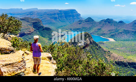 Senior woman enjoying the view of the Blyde River Canyon and Blyde River Dam from the viewpoint at the Three Rondavels in Mpumalanga, South Africa Stock Photo