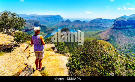 Senior woman enjoying the view of the Blyde River Canyon and Blyde River Dam from the viewpoint at the Three Rondavels along the Panorama Route in Mpu Stock Photo