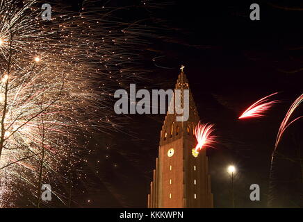 Reykjavík, Iceland, New Year Eve, Fireworks near Hallgrímskirkja - modern cathedral with striking bell tower. Stock Photo
