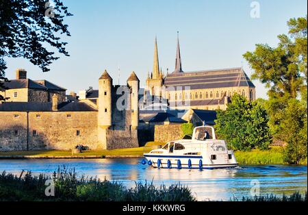 Pleasure boat on River Erne waterway passing Enniskillen Castle and St. Macartin’s Cathedral, Enniskillen, County Fermanagh. Stock Photo