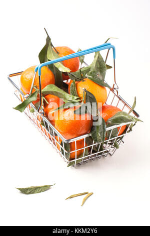 Metal food basket full of tangerines with leaves isolated over white Stock Photo