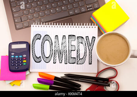 Word writing Comedy in the office with laptop, marker, pen, stationery, coffee. Business concept for Stand Up Comedy Microphone Workshop white backgro Stock Photo