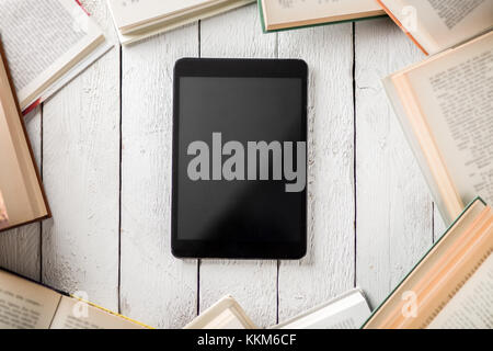 Black Ebook Reader with Many Paper Books Stock Photo