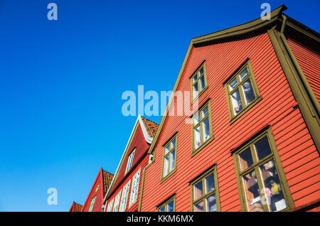 Traditional Norwegian red wooden houses under deep blue sky, Bergen Bryggen Stock Photo