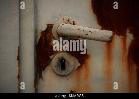 Rusted door lock of a court driveway with cracked grey varnish and rust Stock Photo