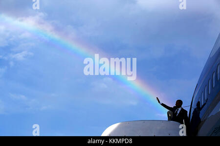 President Barack Obama's wave aligns with a rainbow as he boards Air Force One at Norman Manley International Airport prior to departure from Kingston, Jamaica, April 9, 2015. (Official White House Photo by Pete Souza)  This official White House photograph is being made available only for publication by news organizations and/or for personal use printing by the subject(s) of the photograph. The photograph may not be manipulated in any way and may not be used in commercial or political materials, advertisements, emails, products, promotions that in any way suggests approval or endorsement of th Stock Photo