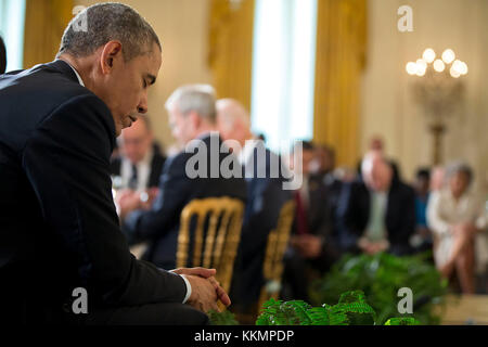 President Barack Obama bows his head during the closing prayer at the Easter Prayer Breakfast in the East Room of the White House, April 7, 2015. (Official White House Photo by Pete Souza)  This official White House photograph is being made available only for publication by news organizations and/or for personal use printing by the subject(s) of the photograph. The photograph may not be manipulated in any way and may not be used in commercial or political materials, advertisements, emails, products, promotions that in any way suggests approval or endorsement of the President, the First Family, Stock Photo