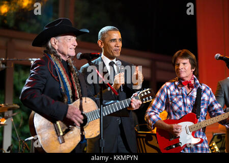 President Barack Obama joins Willie Nelson and John Fogerty onstage at the conclusion of 'A Salute to the Troops: In Performance at the White House' on the South Lawn of the White House, Nov. 6, 2014. (Official White House Photo by Pete Souza)  This official White House photograph is being made available only for publication by news organizations and/or for personal use printing by the subject(s) of the photograph. The photograph may not be manipulated in any way and may not be used in commercial or political materials, advertisements, emails, products, promotions that in any way suggests appr Stock Photo
