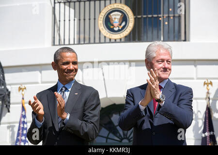 President Barack Obama and former President Bill Clinton applaud during the 20th anniversary of the AmeriCorps national service program on the South Lawn of the White House, Sept. 12, 2014. Stock Photo